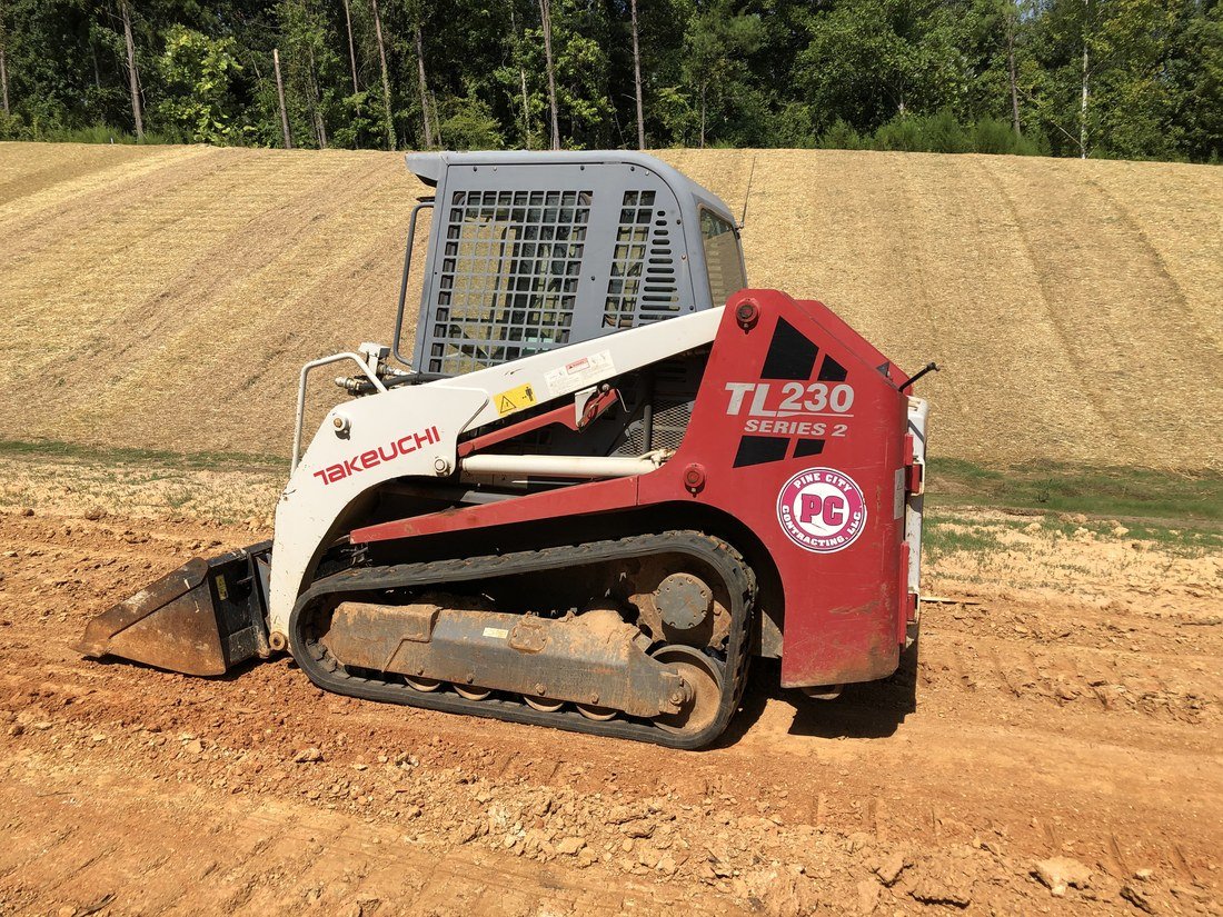 A compact track loader on a graded jobsite.