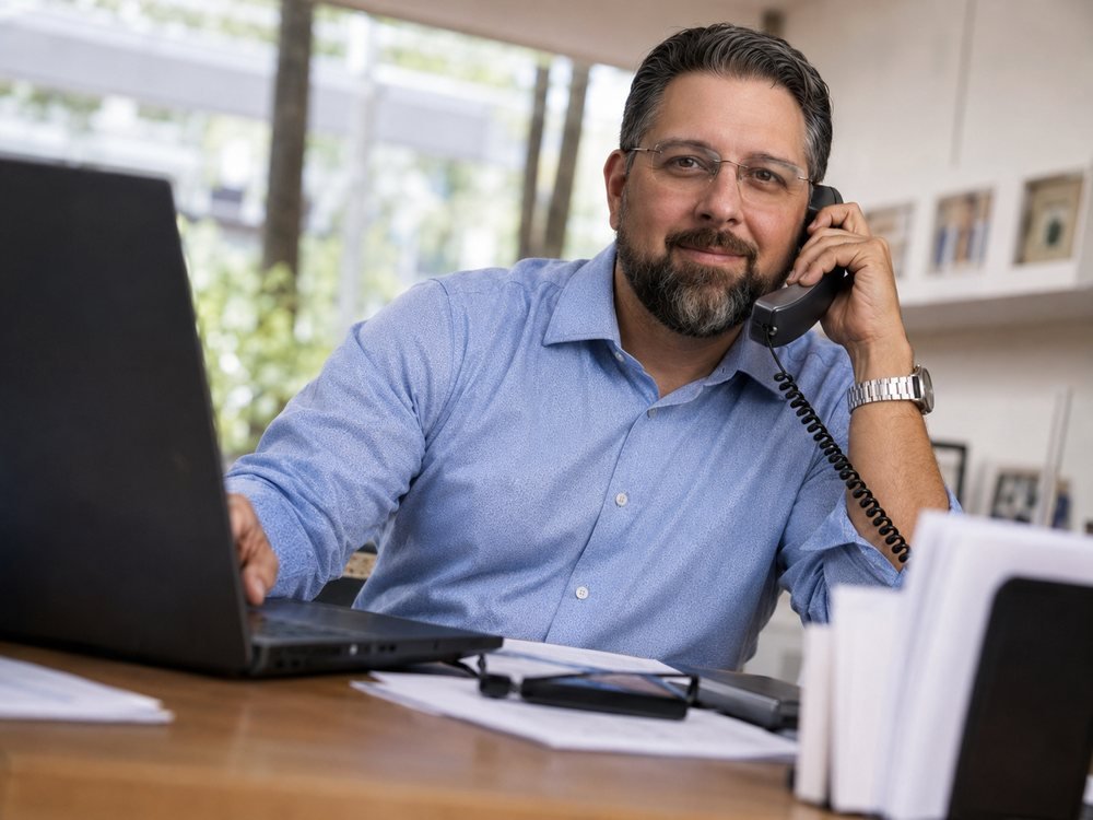 Nathan Bazzle, MCMEA, on the phone at his desk