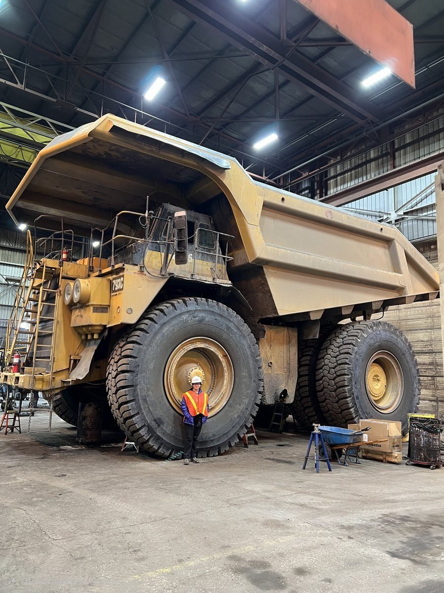Amanda Bazzle standing beside a CAT 793C haul truck, Wyoming