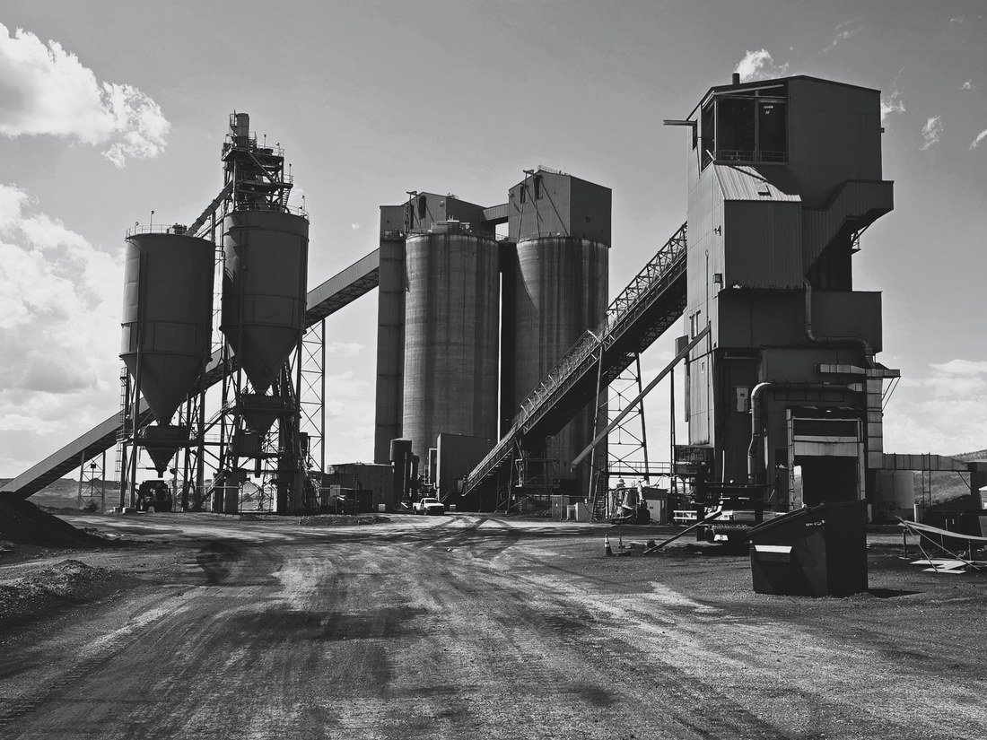 A coal preparation and wash plant with silos, conveyors, and screening structures against the sky.