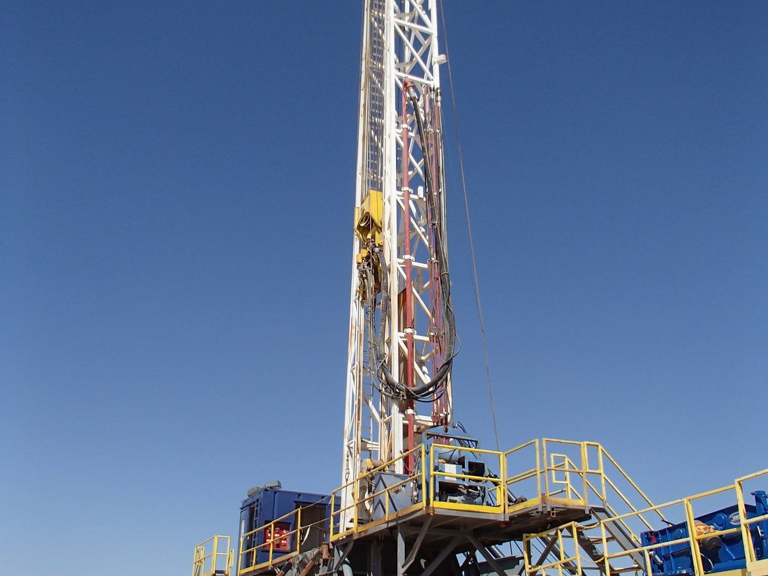 A drilling rig substructure and derrick at an oil and gas site.