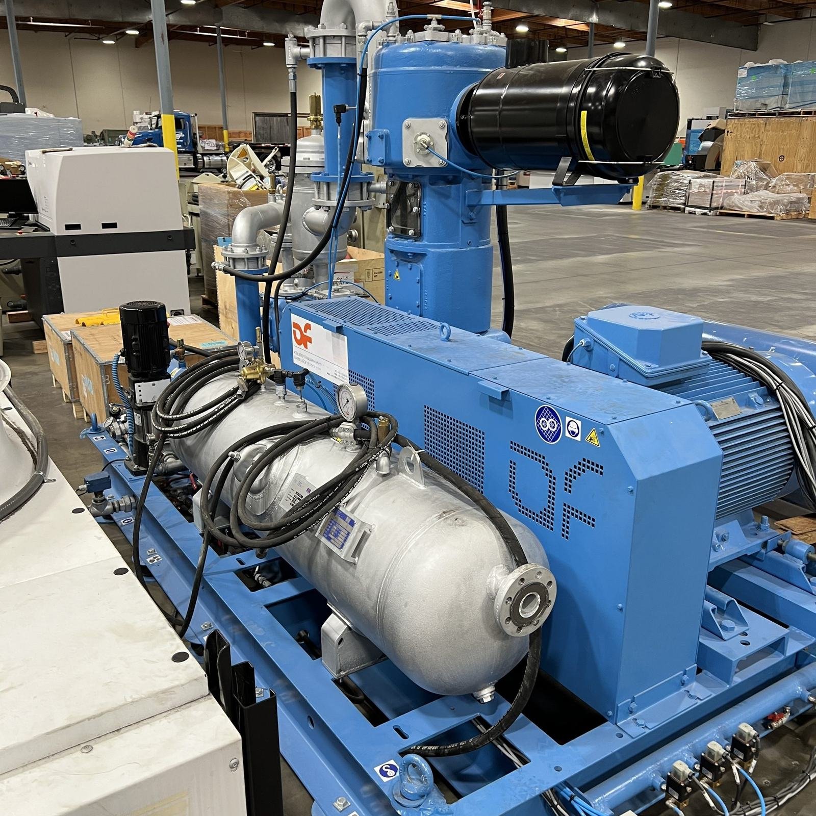 A high-pressure air compressor package serving a PET stretch-blow molding machine.