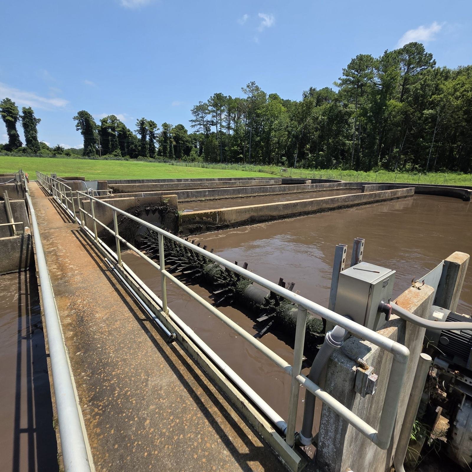 A railed walkway along a treatment basin at a wastewater plant.